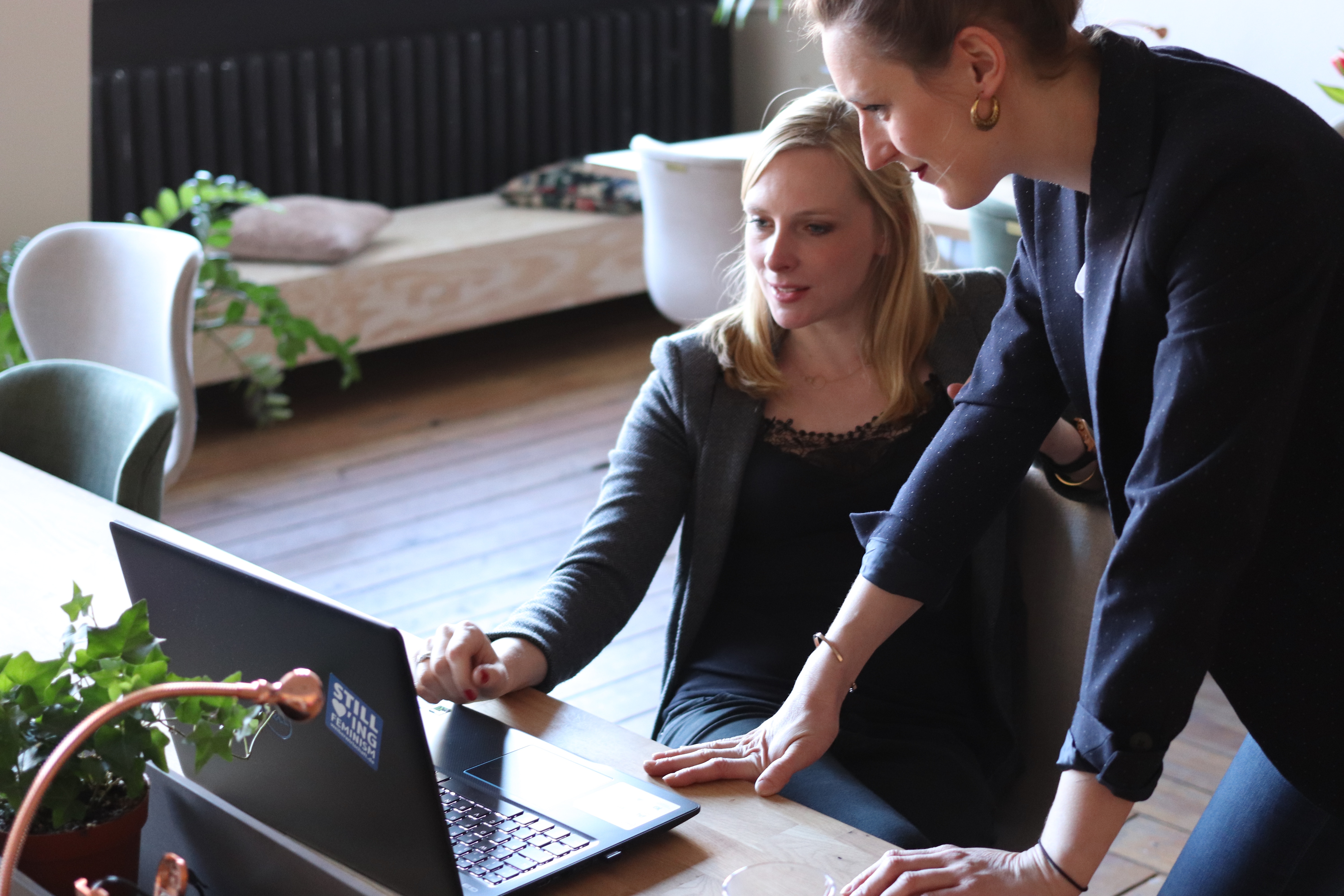How to Plan a Corporate Event in 9 Easy Steps two women at a laptop working on scheduling their next event